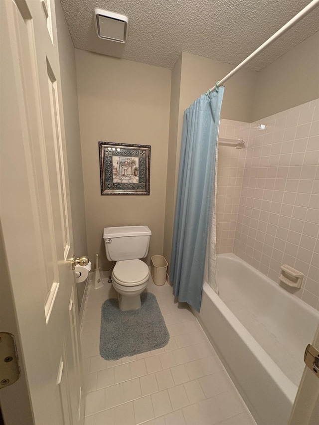 bathroom with tile patterned floors, a textured ceiling, shower / bath combo, and toilet