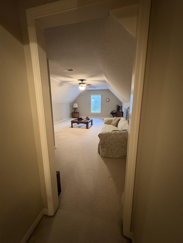 carpeted bedroom featuring ceiling fan, lofted ceiling, and a textured ceiling