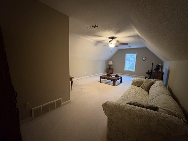 carpeted living room with a textured ceiling, ceiling fan, and vaulted ceiling