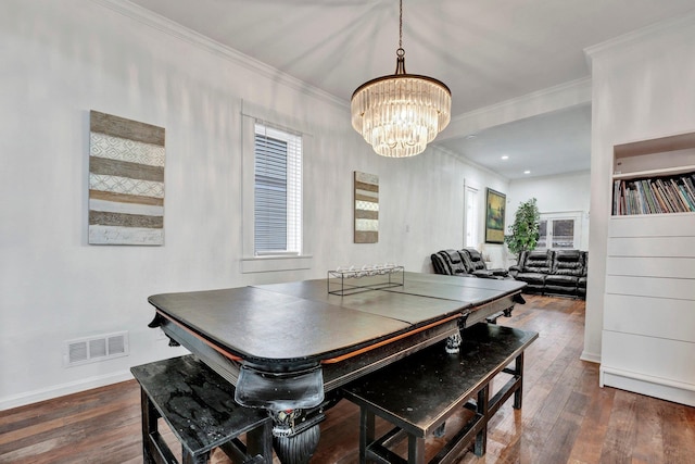 dining room with ornamental molding, an inviting chandelier, and dark wood-type flooring