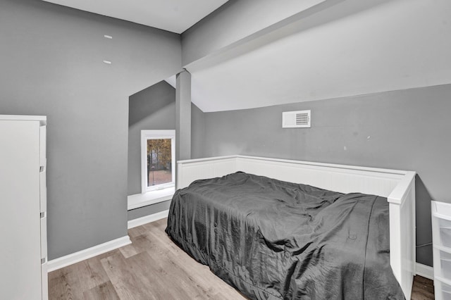 bedroom with light hardwood / wood-style floors and vaulted ceiling