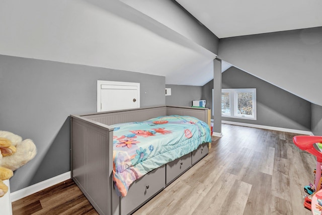 bedroom featuring light hardwood / wood-style floors and vaulted ceiling