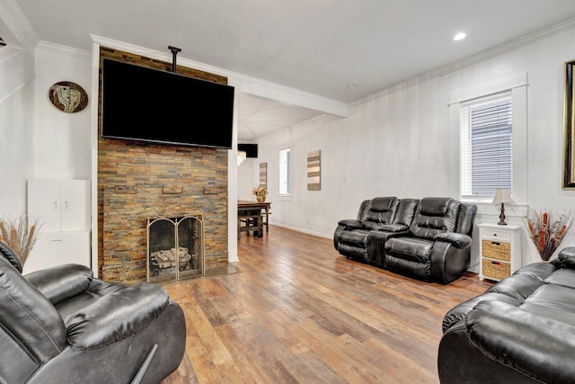 living room with plenty of natural light, light hardwood / wood-style floors, a stone fireplace, and crown molding