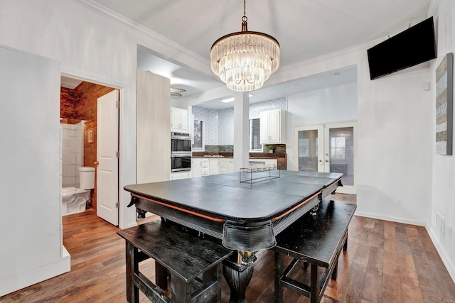 dining area with french doors, light hardwood / wood-style floors, and ornamental molding