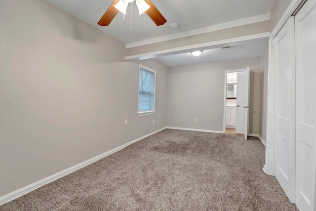 carpeted spare room featuring ceiling fan and crown molding