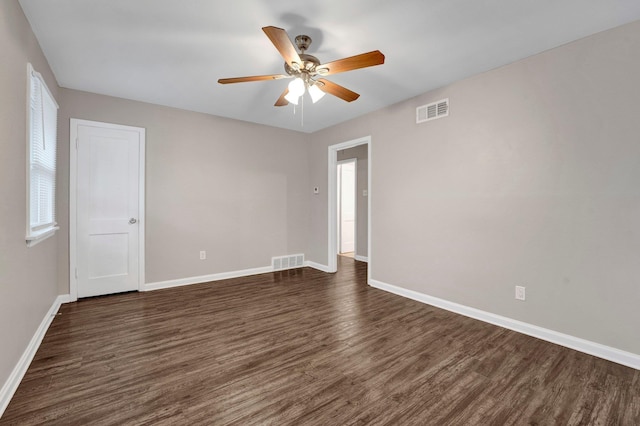 empty room with dark hardwood / wood-style flooring and ceiling fan