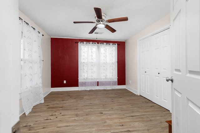 unfurnished bedroom featuring ceiling fan, a closet, and light hardwood / wood-style flooring