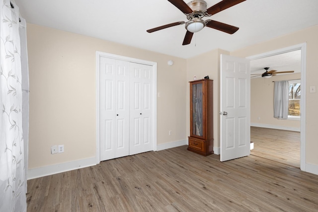 unfurnished bedroom featuring ceiling fan, light wood-type flooring, and a closet