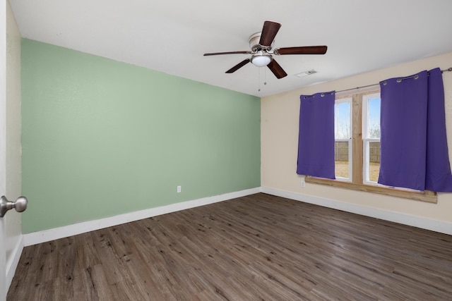 unfurnished room with ceiling fan and dark hardwood / wood-style flooring