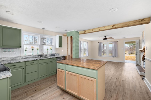 kitchen featuring a textured ceiling, ceiling fan, sink, a center island, and light hardwood / wood-style floors