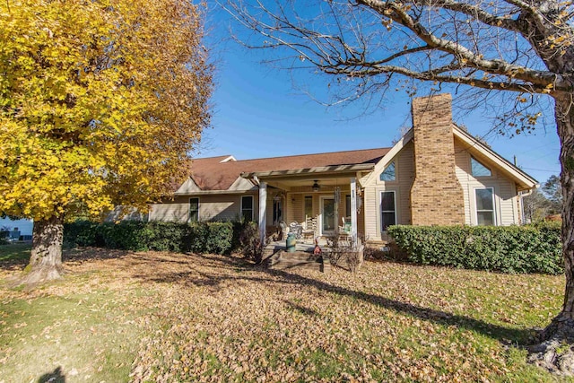 back of house featuring ceiling fan and a yard