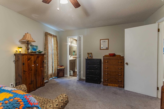 carpeted bedroom with ensuite bath, ceiling fan, and a textured ceiling