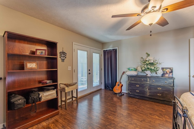 living area featuring dark hardwood / wood-style flooring, ceiling fan, french doors, and a textured ceiling