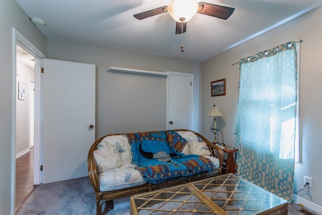 sitting room featuring carpet flooring, ceiling fan, and a textured ceiling