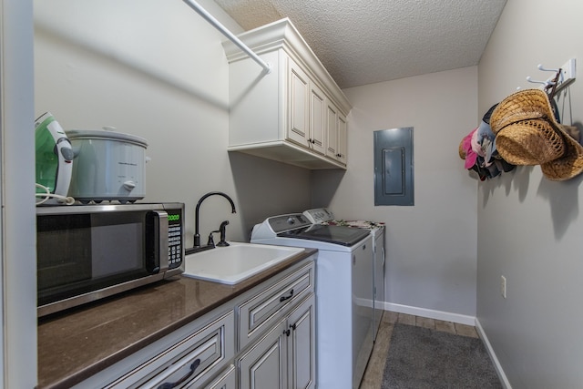 clothes washing area featuring sink, dark wood-type flooring, electric panel, a textured ceiling, and washer and clothes dryer