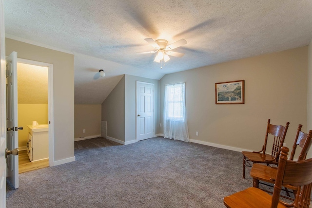 sitting room featuring a textured ceiling, ceiling fan, carpet, and lofted ceiling