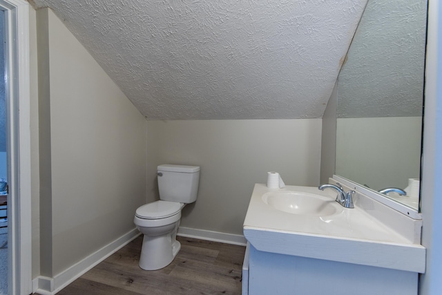 bathroom featuring vanity, toilet, wood-type flooring, and vaulted ceiling