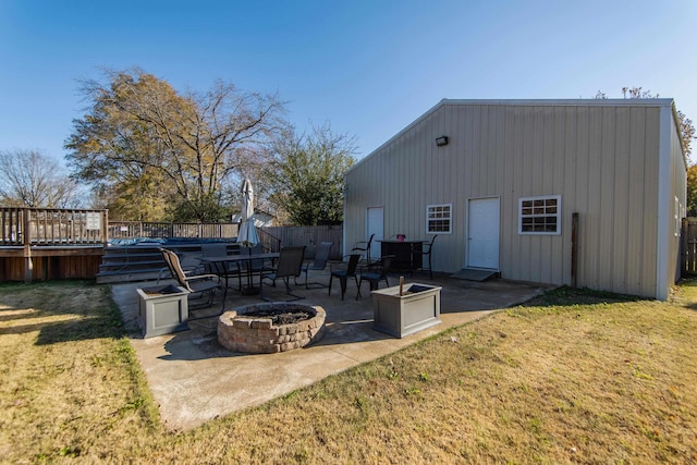 exterior space featuring a fire pit, a yard, a patio, and a wooden deck