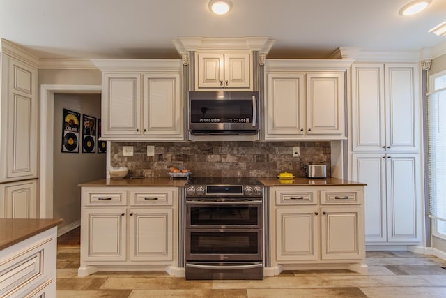 kitchen with light wood-type flooring, crown molding, appliances with stainless steel finishes, and cream cabinets