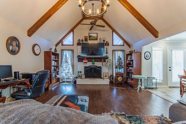 living room featuring high vaulted ceiling, dark wood-type flooring, ceiling fan with notable chandelier, and a brick fireplace