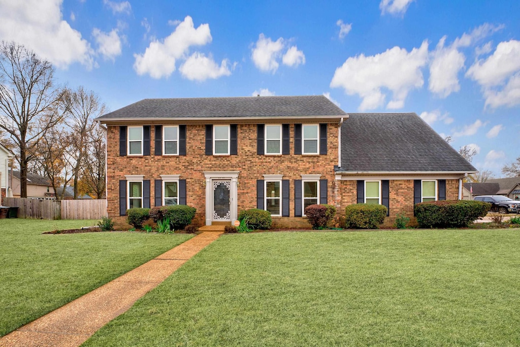 colonial-style house with a front lawn