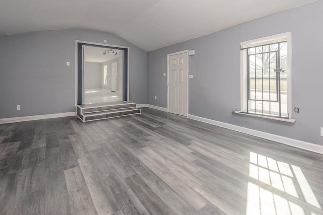 additional living space with dark wood-type flooring and vaulted ceiling