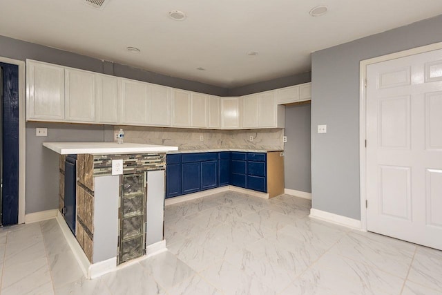 kitchen featuring blue cabinetry, white cabinets, and decorative backsplash