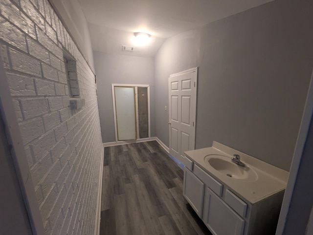 bathroom featuring hardwood / wood-style flooring, vanity, and lofted ceiling