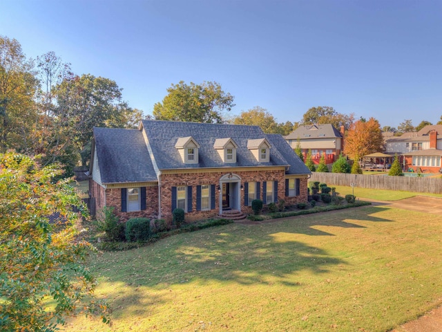 cape cod home with a front yard