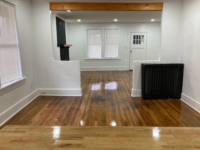 interior space with beamed ceiling and dark wood-type flooring