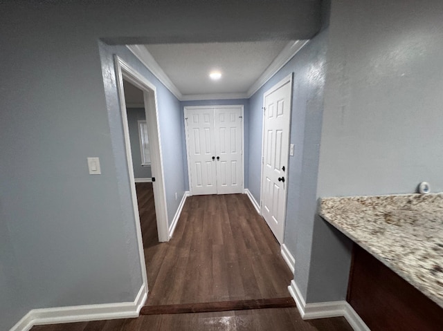 corridor with dark wood-type flooring and ornamental molding