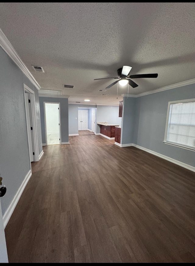 unfurnished living room with a textured ceiling, crown molding, ceiling fan, and dark wood-type flooring