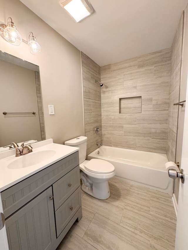 full bathroom featuring toilet, vanity, and tiled shower / bath