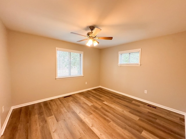 unfurnished room featuring ceiling fan, plenty of natural light, and hardwood / wood-style flooring