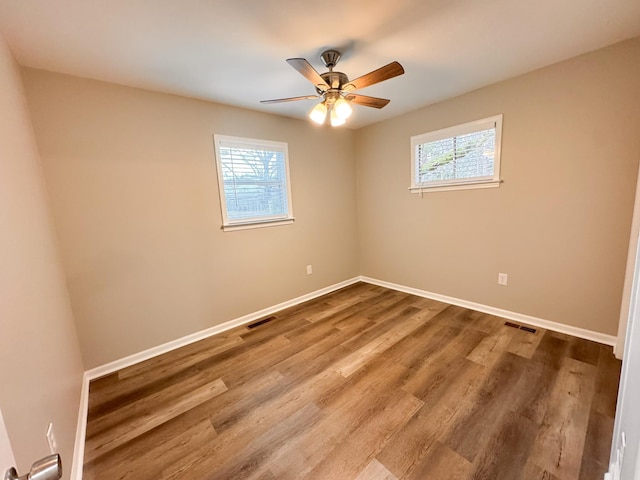 spare room with hardwood / wood-style flooring, a wealth of natural light, and ceiling fan