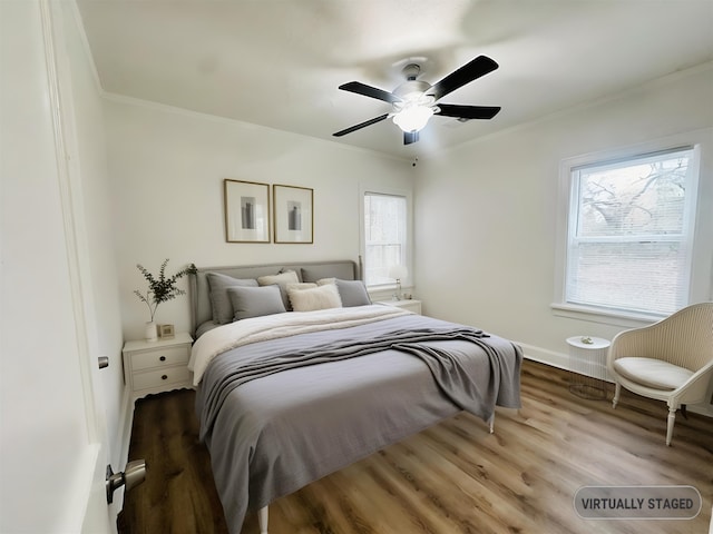 bedroom with wood-type flooring, ceiling fan, and crown molding