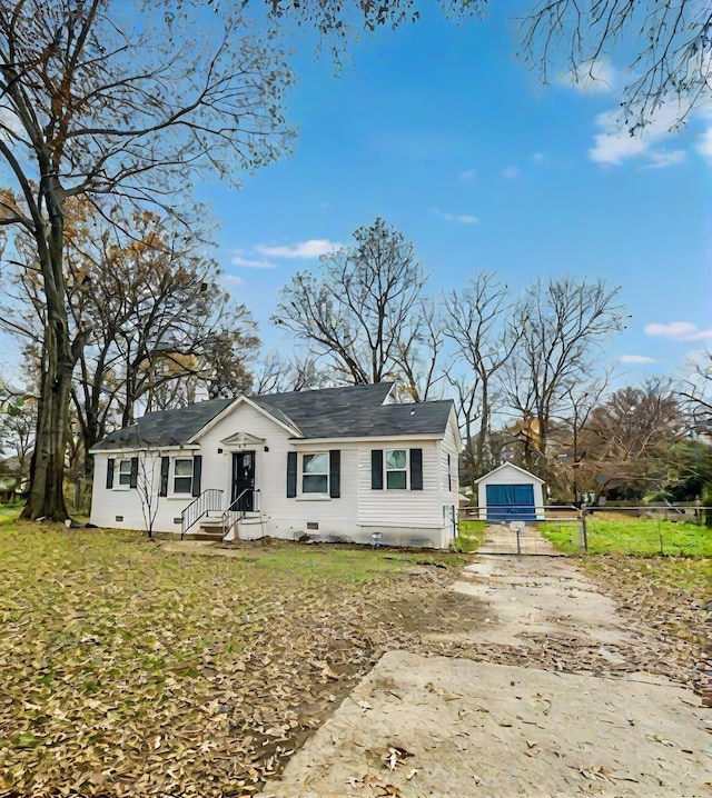 view of front of home featuring a garage, a front lawn, and an outdoor structure