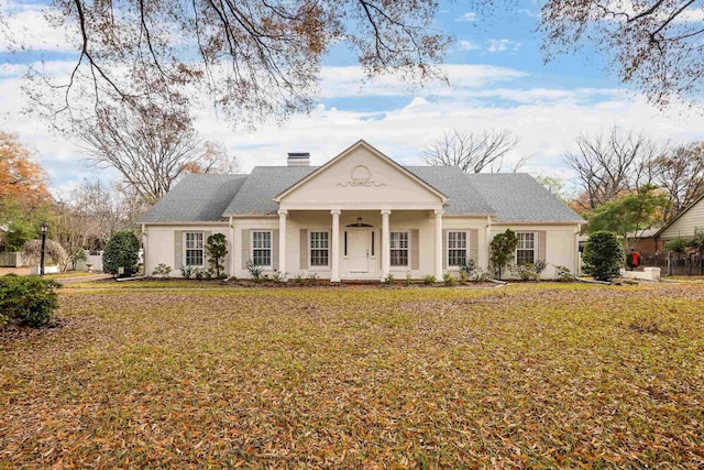 greek revival inspired property featuring a front lawn