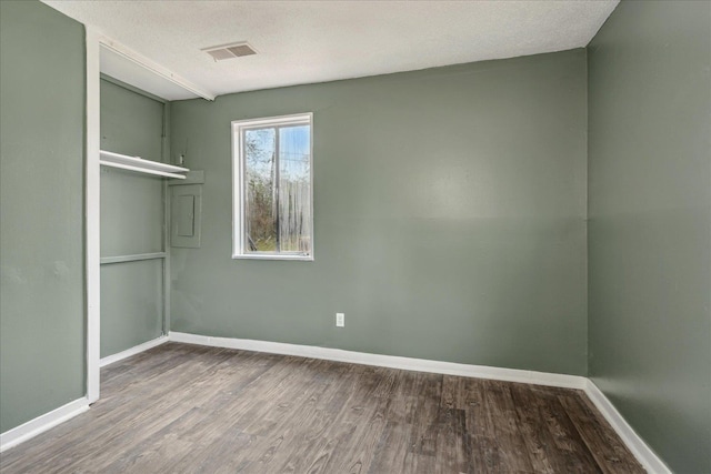 spare room with wood-type flooring and a textured ceiling