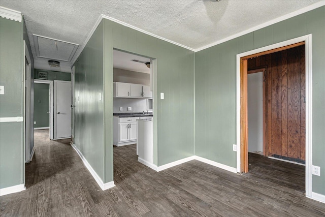 interior space with a textured ceiling, wood walls, dark hardwood / wood-style floors, and ornamental molding