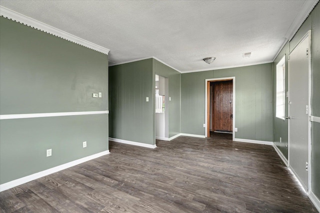 empty room with a textured ceiling, dark hardwood / wood-style flooring, plenty of natural light, and ornamental molding