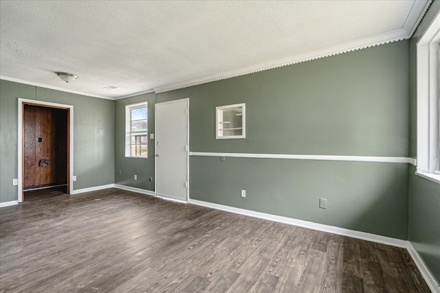 empty room with hardwood / wood-style flooring, crown molding, and a textured ceiling