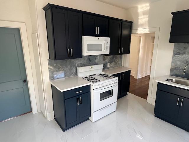 kitchen with white appliances, tasteful backsplash, and sink