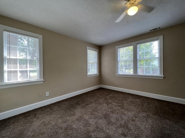 carpeted spare room featuring ceiling fan and a textured ceiling