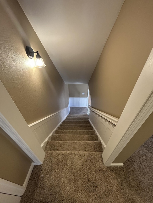 staircase featuring carpet floors and wainscoting