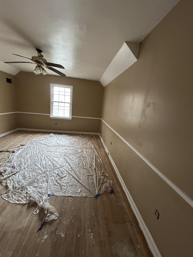 bonus room featuring visible vents, baseboards, a ceiling fan, lofted ceiling, and wood finished floors