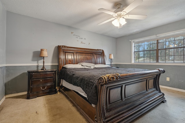 bedroom featuring light carpet, a textured ceiling, and ceiling fan