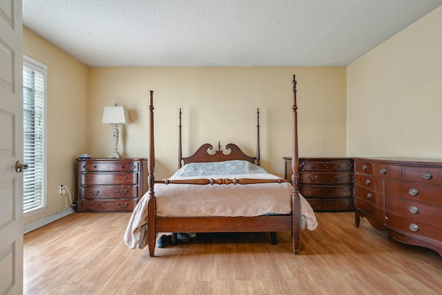 bedroom with light hardwood / wood-style flooring and a textured ceiling