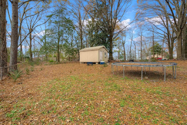 view of yard with a trampoline and a storage shed