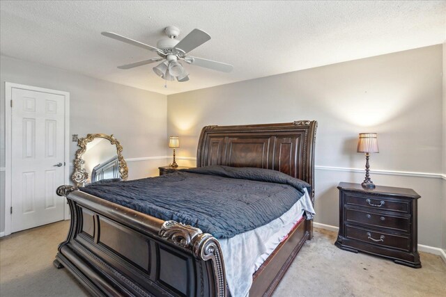 bedroom featuring light colored carpet, a textured ceiling, and ceiling fan